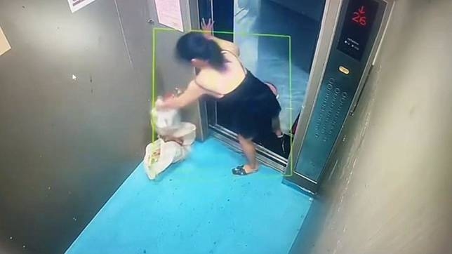 A woman pours trash and dirty water into the elevator.