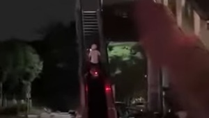 Despite the danger, the woman rides a motorbike on the escalator.