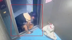 A woman pours trash and dirty water into the elevator.