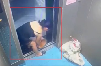 A woman pours trash and dirty water into the elevator.